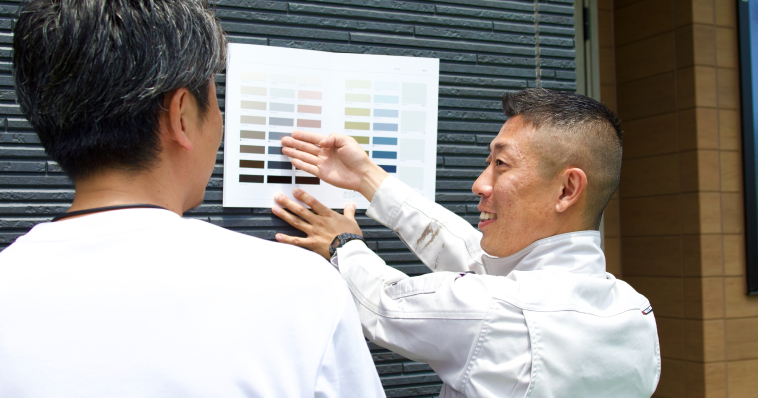 色カタログを壁に合わせてお客様と見ている様子